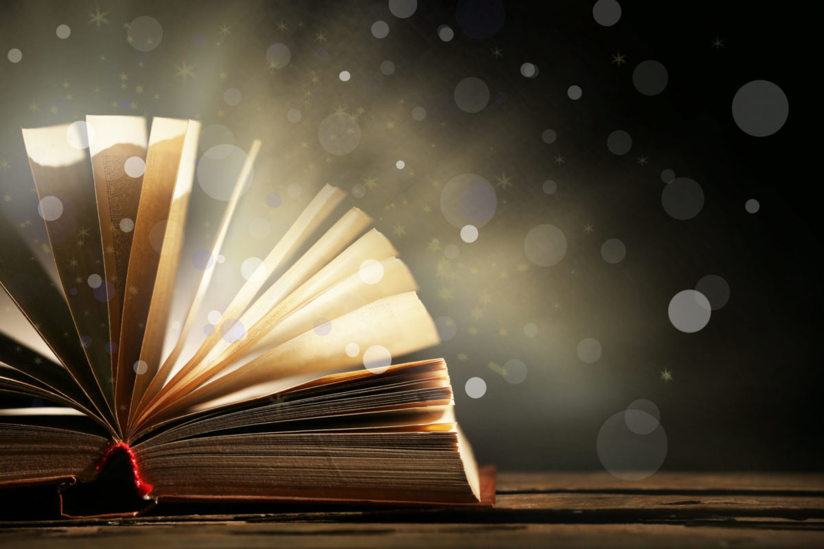 Open book on shiny dark background